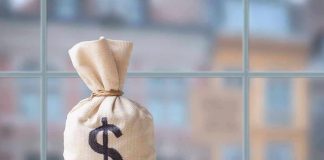 Money bag with dollar sign on table.