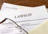Documents labeled "Lawsuit" with glasses on top.