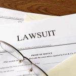 Documents labeled "Lawsuit" with glasses on top.