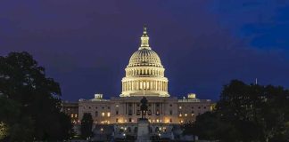 Illuminated capitol building at night with reflection in water