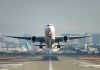 Airplane taking off from runway in urban area