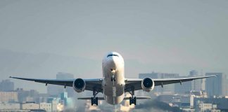Airplane taking off from runway in urban area