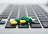Various colored pills scattered on a laptop keyboard
