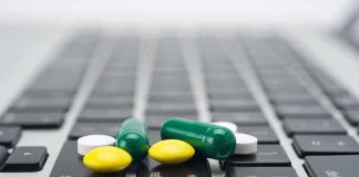 Various colored pills scattered on a laptop keyboard