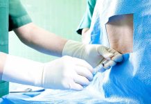Healthcare professional administering an injection to a patient in a surgical setting