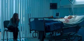 Woman sitting beside hospital bed at night