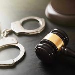 Handcuffs and judges gavel on the table