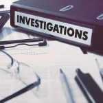 Documents and binder labeled Investigations on desk