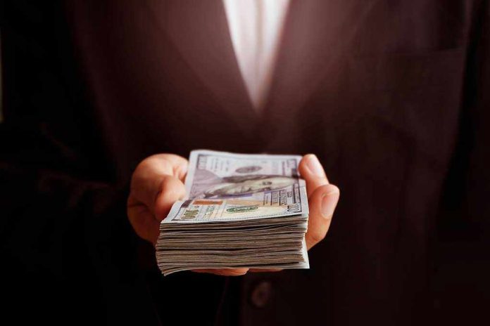 71912373 Hand holding a stack of hundred dollar bills