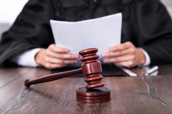 A judge holding documents with a gavel in the foreground