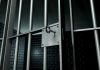 Close-up of a locked prison gate with metal bars