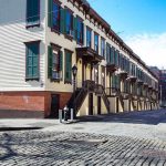 Row houses along a cobblestone street in an urban setting