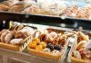 A display case filled with various types of baked goods including breads and pastries