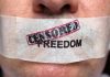 Close up of a persons mouth covered with tape that reads CENSORED FREEDOM