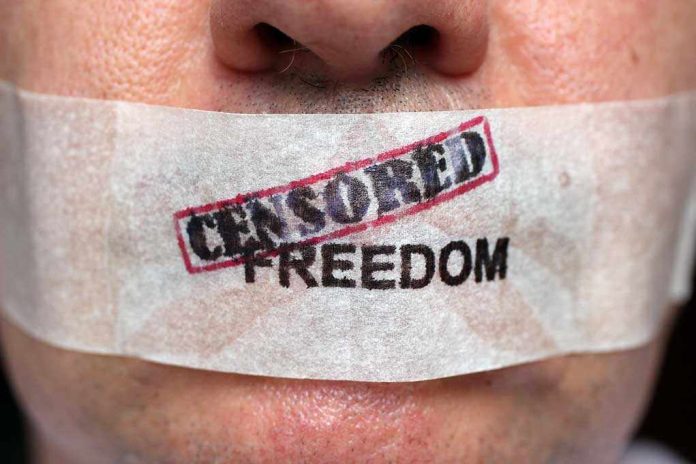 Close up of a persons mouth covered with tape that reads CENSORED FREEDOM