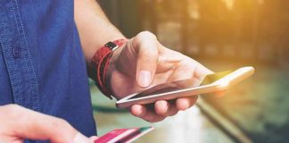 Person holding a smartphone and a credit card preparing for a digital transaction
