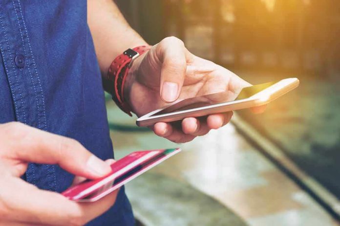 Person holding a smartphone and a credit card preparing for a digital transaction
