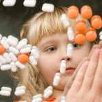 A child observing colorful pills floating in the air