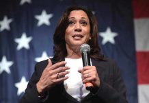 Woman speaking with microphone American flag background