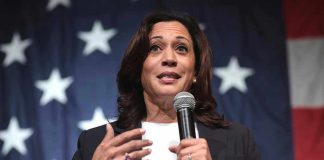 Woman speaking with microphone American flag background